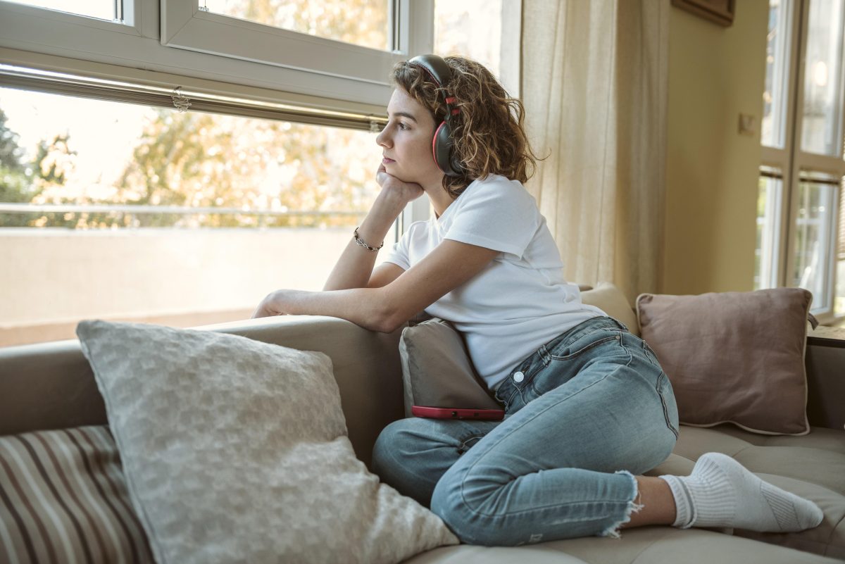 Adolescente che guarda fuori dalla finestra in modo pensieroso, simbolo di introspezione e cambiamento durante la crescita